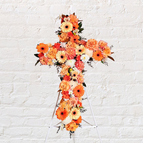 Orange flowers cross wreath with white stand