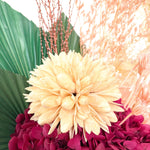 A mix of preserved flowers and silk flowers of hydrangea, magnolia flower, cherry blossom, honesty, nigella, cloudy leaf, misty and palm in a in white vase.